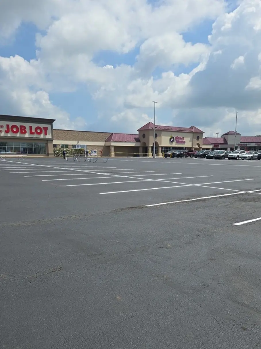 Wide aerial-style view of a freshly striped retail center parking lot